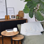 Bild mit einer Decke auf einem Sofa in wohnlicher Umgebung mit einem Couchtisch mit Teetasse und einem Buch