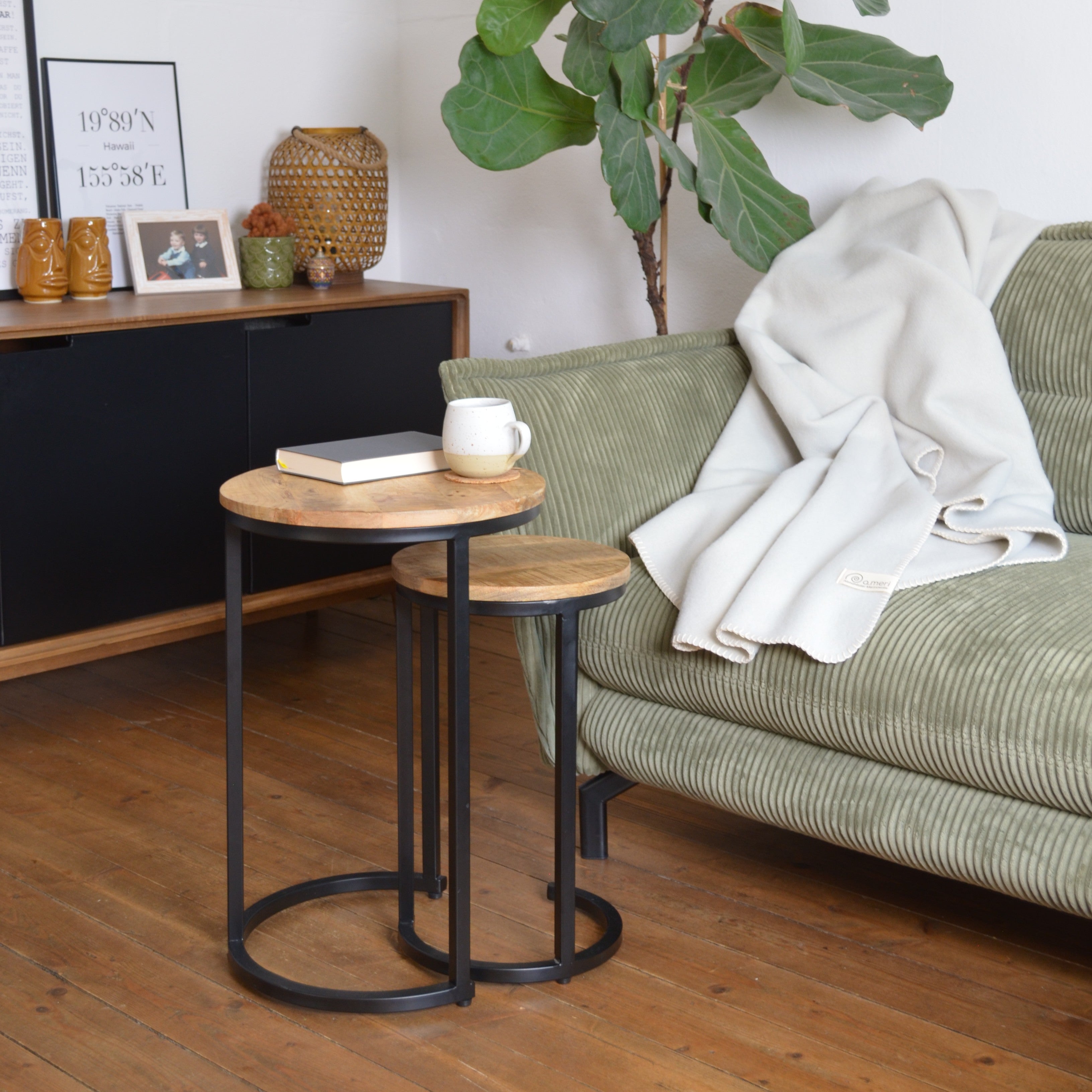 Bild mit einer Decke auf einem Sofa in wohnlicher Umgebung mit einem Couchtisch mit Teetasse und einem Buch