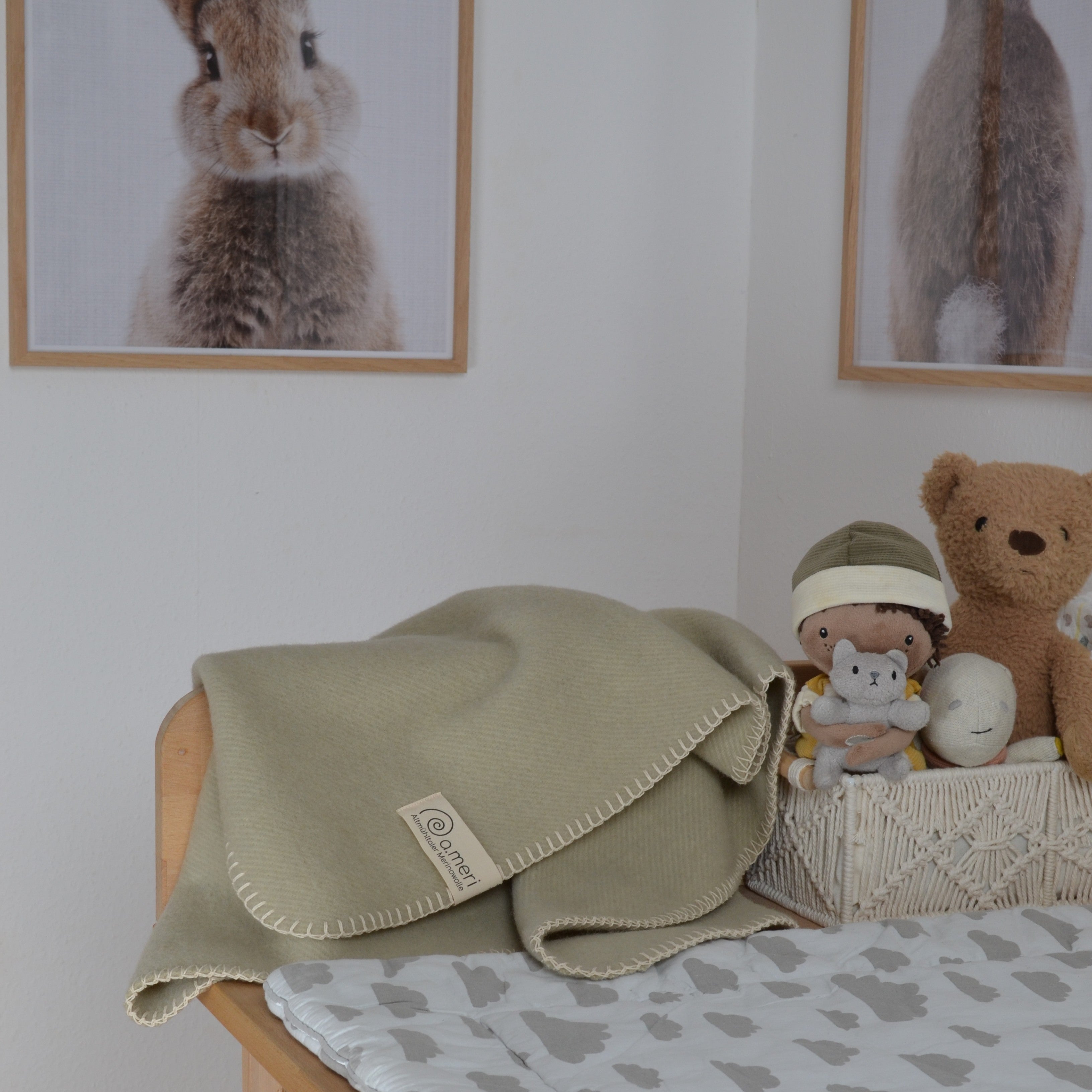Bild mit der Decke Kinding in der Farbe Wacholderast. Decke liegt auf einer Wickelkommode